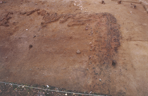 Kuva: Asumuspainne 2 7:ssä tasossa. Kuvassa esillä kivikautisen talon nurkkarakennetta. Kaarlo Katiskoski 1999