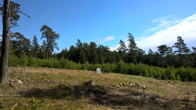 Kuva: Kappelinpaikka ja sitä ympäröivä hautausmaa ja kiviaita. Muistomerkki kappelin keskellä. Kuvattu lännestä. Sirkka-Liisa Seppälä 2018