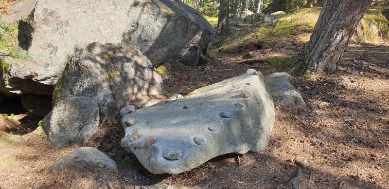 Kuva: Soiva kivi  lounaasta, reunojen kuopissa kumistelukivet Teija Tiitinen 11.8.2021