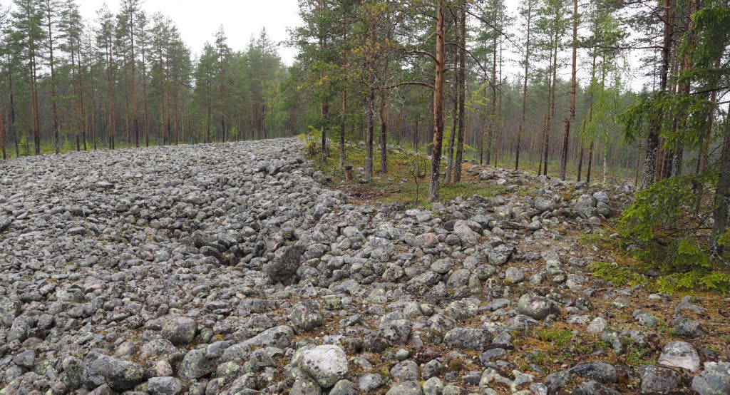 Kuva: Oulu Mäntyselkä. Rakkaan raivattu jätinkirkko kuvattuna kohti pohjoista. Rakkakivikossa on rakkakuoppia ja röykkiömäisiä ladelmia. Teemu Mökkönen 5.6.2020