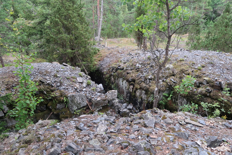 Kuva: Kuvassa näkyy kallioon luohittua hautaa sekä louhinnasta syntyneitä louhekivikasoja haudan ympäristössä. Helsingin kaupunginmuseo. CC BY 4.0 Heini Hämäläinen 6.8.2020